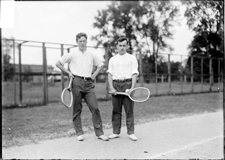 Tennis players, A. P. Nelson and J. W. Bingham, standing on the edge of a tennis court - Chicago Daily News, Inc.