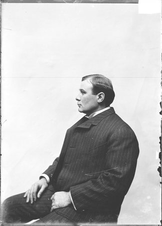 Pugilist, McGee, sitting in profile in front of a light colored backdrop - Chicago Daily News, Inc.