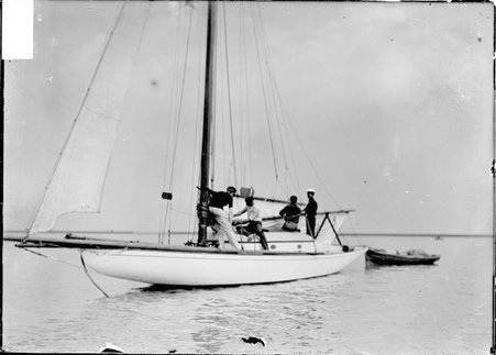 Yacht, Pilot, moored on Lake Michigan with crew working the unfurled mainsail - Chicago Daily News, Inc.