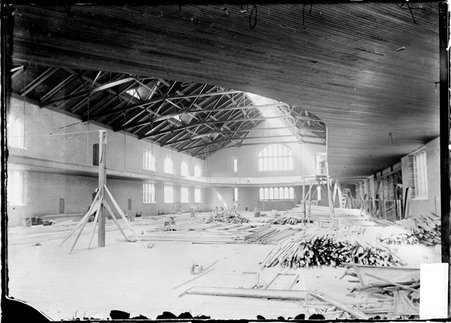 University of Chicago gymnasium under construction with building supplies in piles on the floor - Chicago Daily News, Inc.