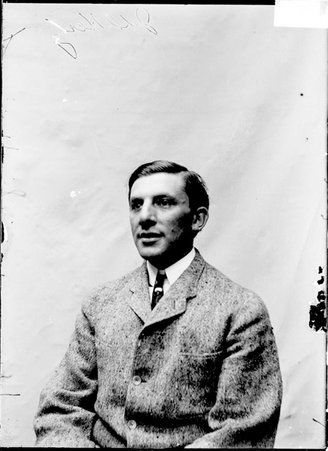 Pugilist, J. D. Hertz, sitting against a plain backdrop - Chicago Daily News, Inc.