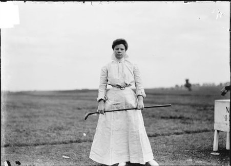 Golfer, Mrs. Elliott Rodgers, holding club horizontally, standing on golf course, Chicago Golf Club - Chicago Daily News, Inc.