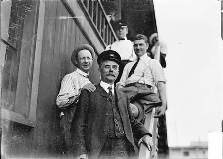 Yachtsman, Commodore McGuire, standing on boathouse stairs with Little Shamrock crew - Chicago Daily News, Inc.