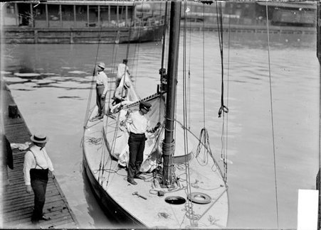 Yachtsmen, Little Shamrock crew, one standing on the dock, four working on the yacht - Chicago Daily News, Inc.