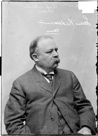 Chess player, Louis Uedemann, in profile, sitting in front of a light colored backdrop - Chicago Daily News, Inc.