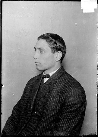 Pugilist, Hugo Kelly, in profile, sitting in front of a light colored backdrop - Chicago Daily News, Inc.