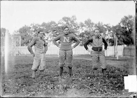 Football team, Northwestern University, three players with hands on hips, standing on an athletic field - Chicago Daily News, Inc.