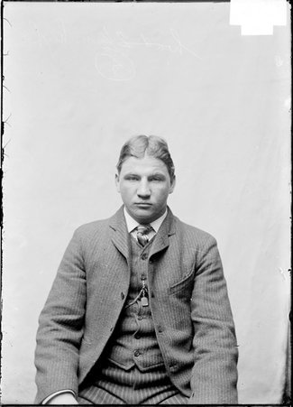 Pugilist, George Memsic, sitting in front of light colored backdrop - Chicago Daily News, Inc.