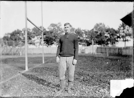 McCormick, Northwestern University coach, standing near a goalpost on an athletic field - Chicago Daily News, Inc.
