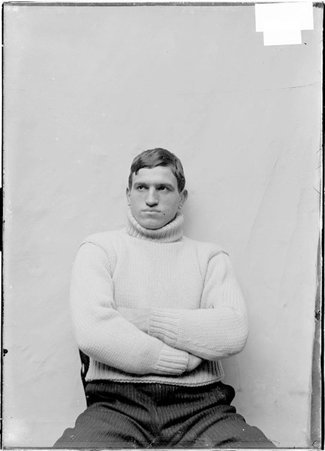 Pugilist, Joe Grim, wearing sweater, facing camera in front of a light colored backdrop - Chicago Daily News, Inc.