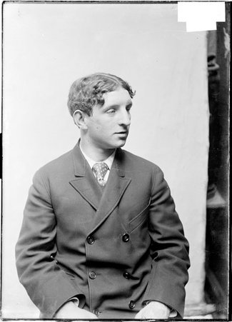 Pugilist, Frankie Neill, looking to his left, sitting in front of a plain backdrop - Chicago Daily News, Inc.