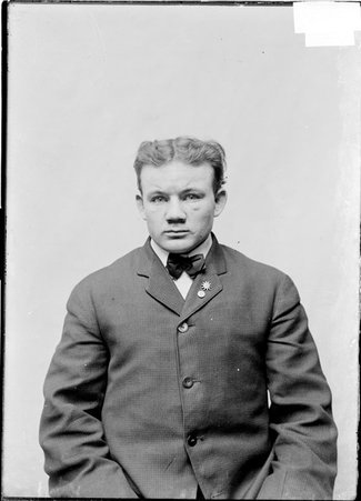 Pugilist, Tom Scully, facing camera, sitting in front of light colored backdrop - Chicago Daily News, Inc.