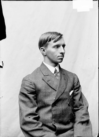 Athlete, L. G. Wilkins, looking to his left, sitting in front of plain backdrop - Chicago Daily News, Inc.