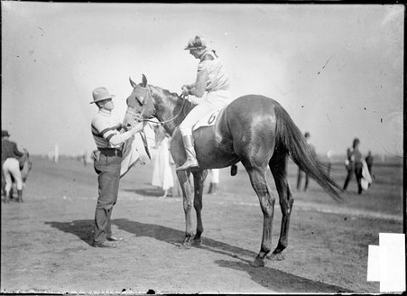 Racehorse, Filo Bob, with jockey, Larsen mounted and handler assisting, standing at Worth Race Track - Chicago Daily News, Inc.