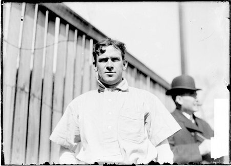Baseball player, Shad Barry, Cincinnati Reds, by a wooden fence - Chicago Daily News, Inc.