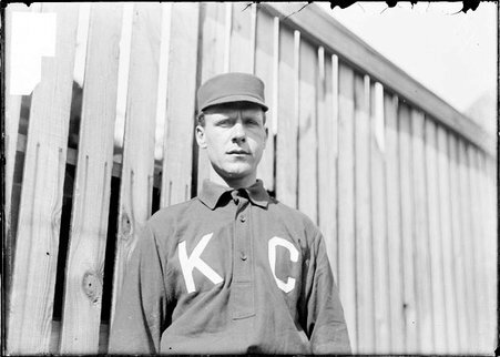 Baseball player, Monte Beville, standing in front of wooden fence - Chicago Daily News, Inc.