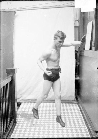 Pugilist, Battling Nelson, standing with left hand palm extended toward wall - Chicago Daily News, Inc.
