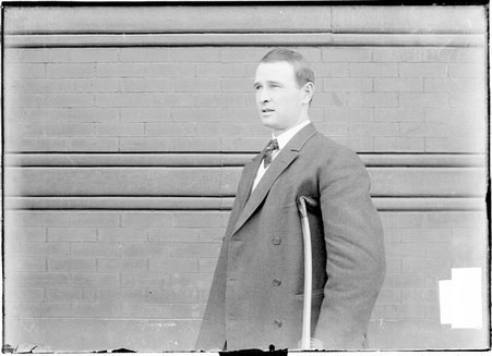 Baseball manager, Frank Chance, Chicago Cubs, on crutches, facing one side, by a brick wall - Chicago Daily News, Inc.
