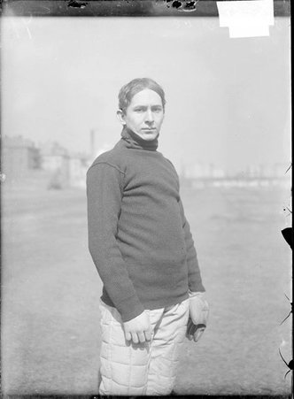 Baseball player, Hopkins, University of Chicago, standing on playing field wearing catcher's glove - Chicago Daily News, Inc.