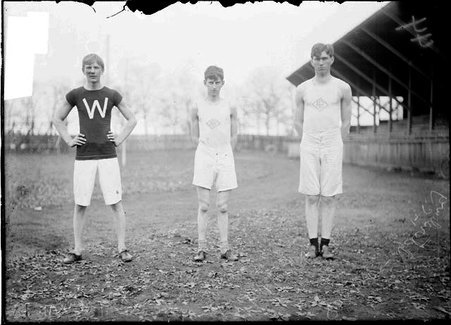 Athletes, Smoot, Samson, and Wandrack, standing near grandstand on an athletic field, Evanston - Chicago Daily News, Inc.