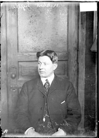 Motorist, Herbert Lytle, sitting in front of a door in a room - Chicago Daily News, Inc.