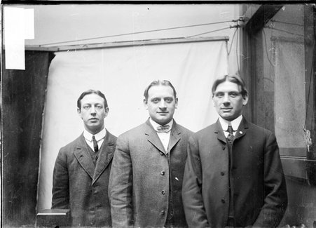 Bowlers, A. Peterson, O. W. Schneider, and P. H. Schneider, standing against a plain backdrop, dark exposure - Chicago Daily News, Inc.