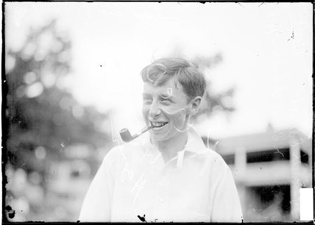 Golfer, Kenneth Edwards, standing outdoors, smoking a pipe - Chicago Daily News, Inc.