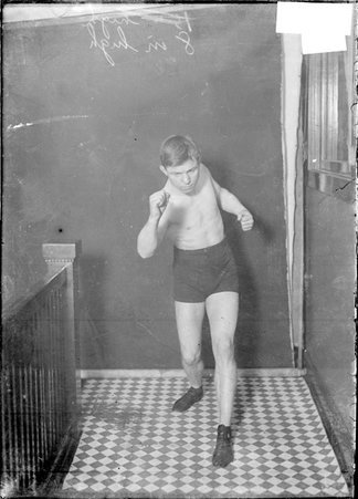 Pugilist, Battling Nelson, standing in boxing stance in Chicago Daily News stairwell hallway - Chicago Daily News, Inc.