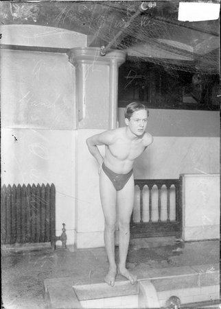 Swimmer, H. J. Handy, standing at edge of indoor pool - Chicago Daily News, Inc.