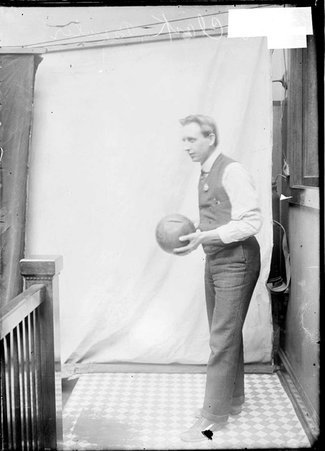 Bowler, H. J. Clark, holding bowling ball, looking up slightly, Chicago Daily News hallway - Chicago Daily News, Inc.