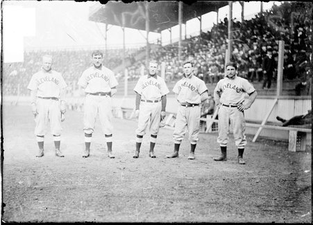 Baseball players, Bemis, Kahl, Bay, and Turner, Cleveland Naps, standing in the dugout by the grandstand, South Side Park - Chicago Daily News, Inc.