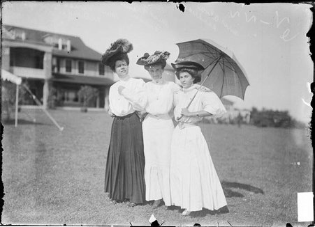Golfers Miriam Anthony, Frances Turner and Alva Sander (with umbrella), standing on the grounds of Homewood Country Club - Chicago Daily News, Inc.