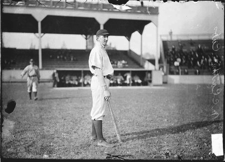 Chicago Cubs baseball player Jack McCarthy standing on the field holding a bat at West Side Grounds - Chicago Daily News, Inc.