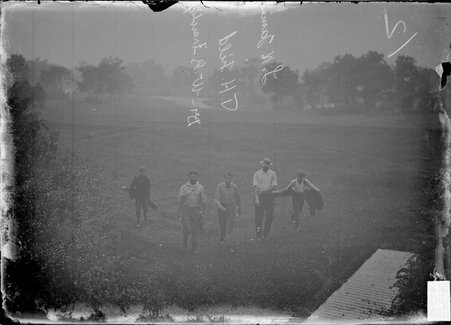 Golfers, James, Field and Frawlick, followed by two caddies, walking on the grounds of Westward Ho Golf Club - Chicago Daily News, Inc.