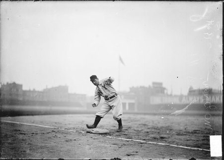 New York Giants baseball player John J. McGraw, standing with foot touching the third base bag and catching a ball, West Side Grounds - Chicago Daily News, Inc.