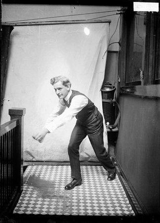 Bowler, Louis Guthmann, standing with his arms reaching forward in a stairwell hallway - Chicago Daily News, Inc.