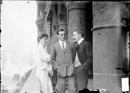 Sir Charles Kirkpatrick, Lady Kirkpatrick and Captain Milnes standing on veranda, Captain Milnes looking at Lady Kirkpatrick - Chicago Daily News, Inc.