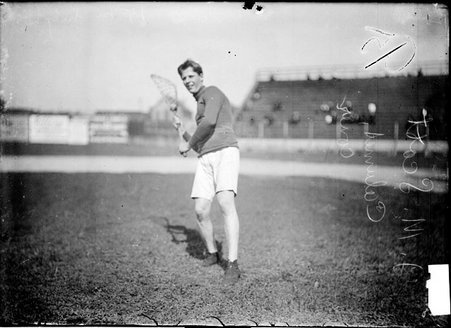 Lacrosse player J. M. Scott standing on the field, holding his stick with both hands and raised over one shoulder - Chicago Daily News, Inc.
