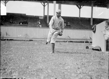 Philadelphia Phillies baseball player Mike Doolan, throwing a ball in the foul zone by the dugout at West Side Grounds - Chicago Daily News, Inc.