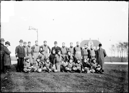University of Michigan football team and five coaches, posing outdoors - Chicago Daily News, Inc.