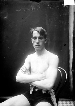 Fred Gilmore, sitting in a chair in front of a light colored background - Chicago Daily News, Inc.