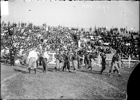 Football, officials and University of Chicago players on the field at Marshall Field - Chicago Daily News, Inc.