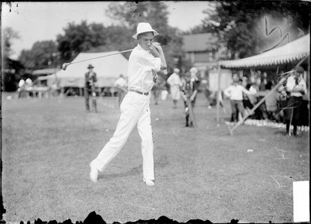 Golfer, R. H. Thatch swinging a club, standing on the clubhouse lawn, Chicago Golf Club - Chicago Daily News, Inc.