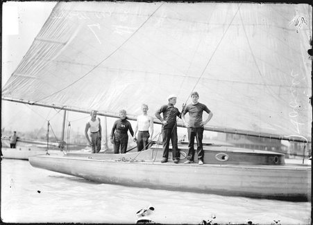 Yachting, five crew members standing on the deck of the yacht Hoosier docked in a marina - Chicago Daily News, Inc.