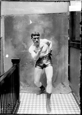 Pugilist, Jack O'Brien, standing in a boxing stance in a stairwell hallway - Chicago Daily News, Inc.