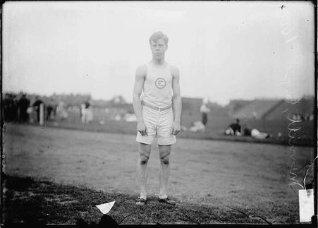 Athlete, N. Merrill, Englewood, standing on the edge of the track - Chicago Daily News, Inc.
