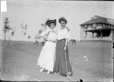 Golfers, Margaret Morris and Miss Alva Sander, standing on clubhouse lawn, Homewood Country Club - Chicago Daily News, Inc.