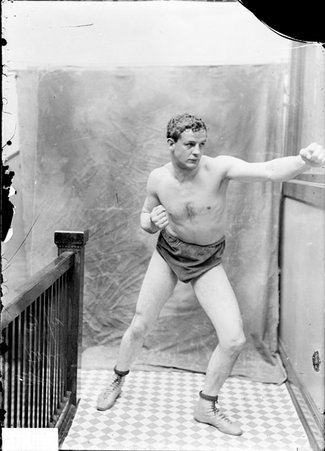 Pugilist, Marvin Hart, standing in a boxing stance in a stairwell hallway - Chicago Daily News, Inc.
