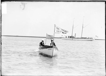 People sitting in a Daily News boat named Lozier on a body of water, boat is pointed to directly at the camera - Chicago Daily News, Inc.