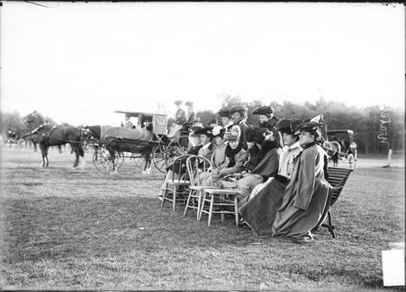 Women posing on and around a bench on the grounds of an unidentified polo field - Chicago Daily News, Inc.